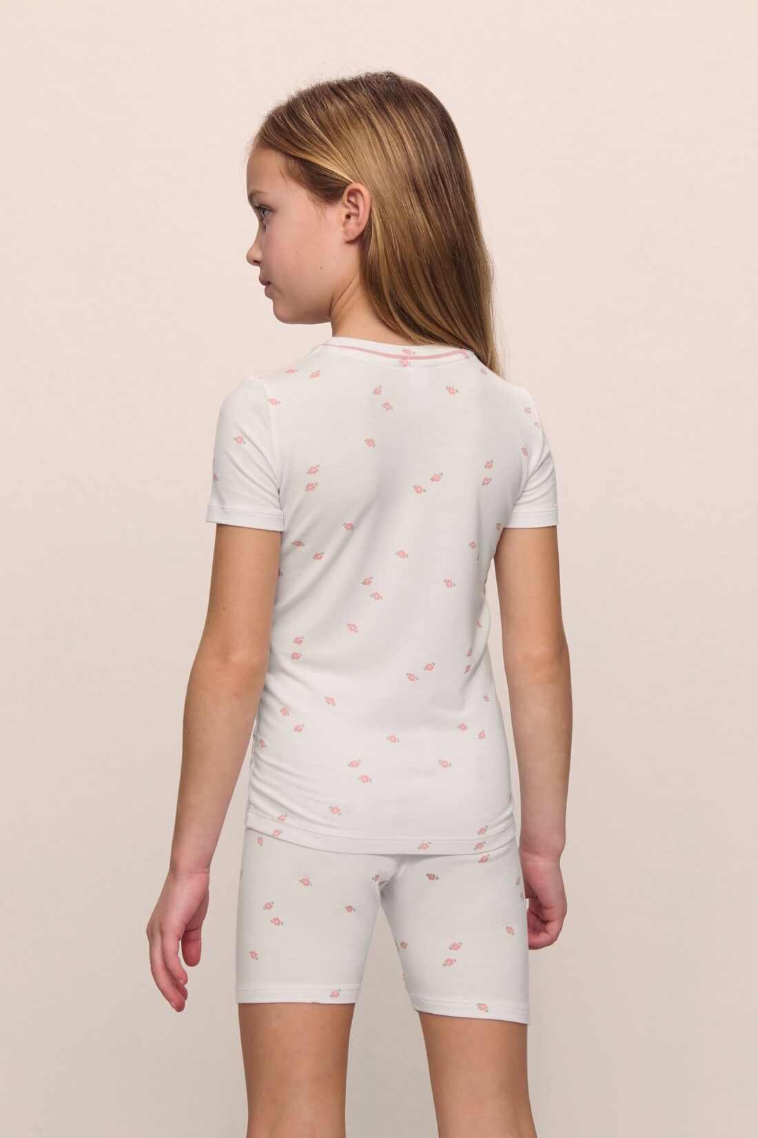 Model is wearing the Kids Printed TENCEL Modal Unisex Short PJ Set in Summer Daisy/Pale Mauve