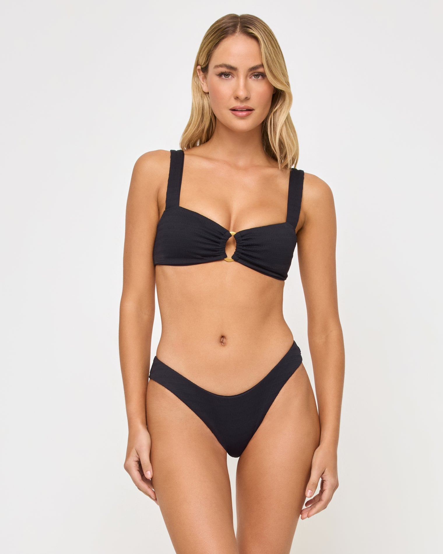 front view of woman wearing a black bikini against a white background
