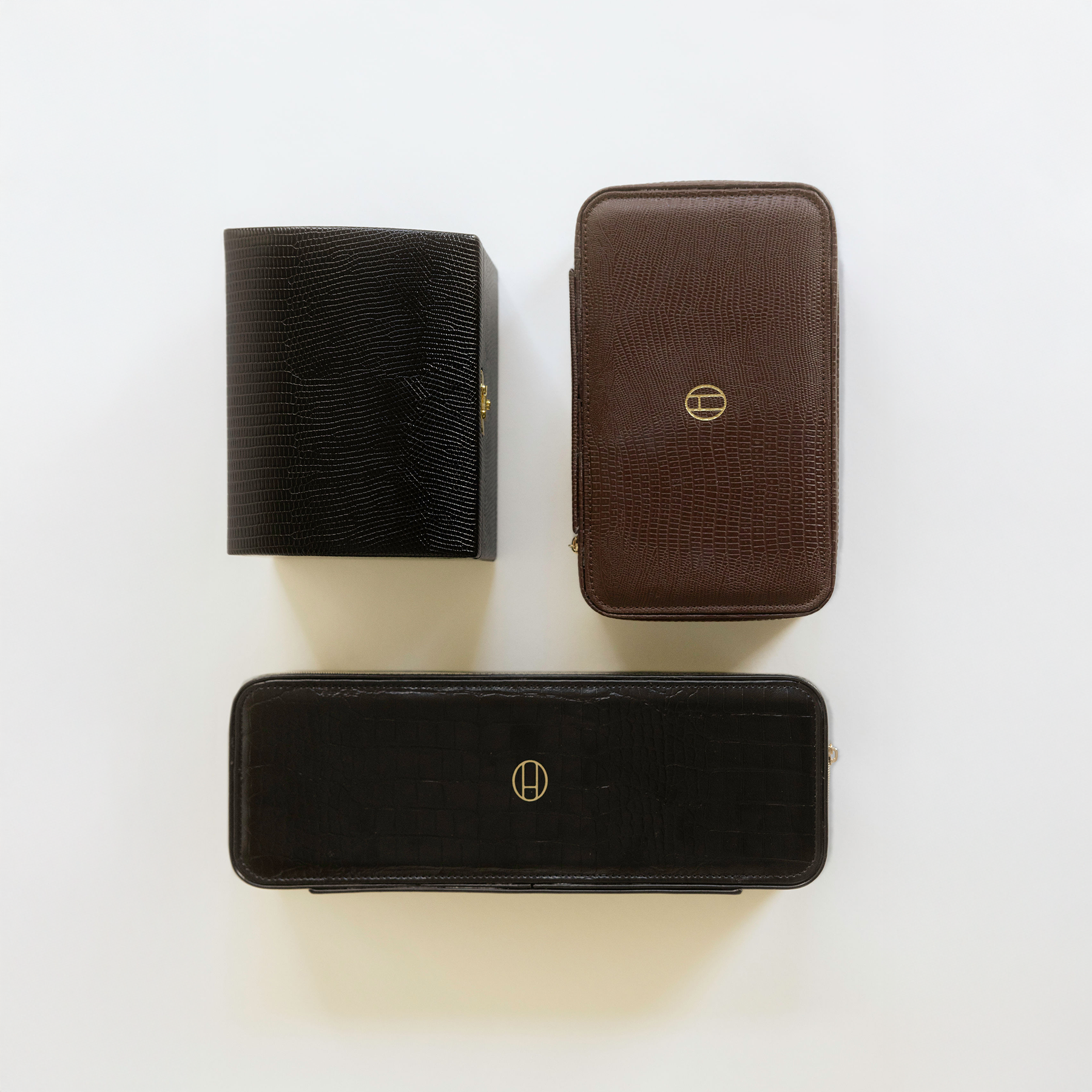 Three black and brown leather cases with a Heaven Mayhem logo on a white background