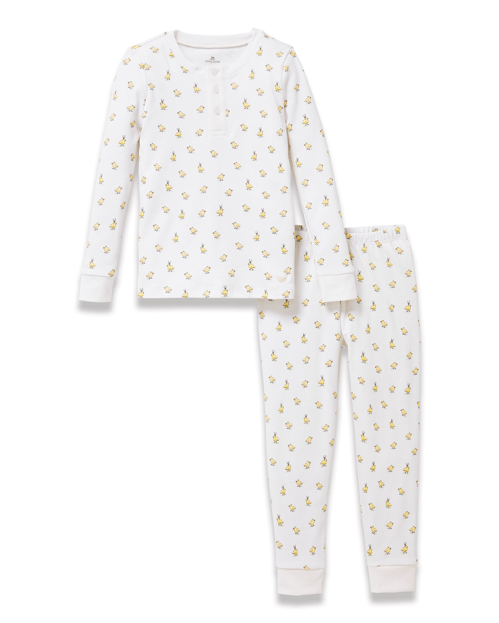 A young child with light brown hair stands barefoot on a plain background, wearing the Kid's Pima Snug Fit Pajama Set in Tres Chick and looking slightly to the side.