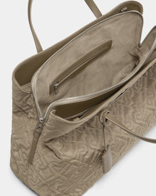The Rudsak ASMINE - L325005 Almond is a taupe quilted monogram tote with double handles, a spacious suede-like lined interior, an inner zip pocket, and an exterior hanging tag.