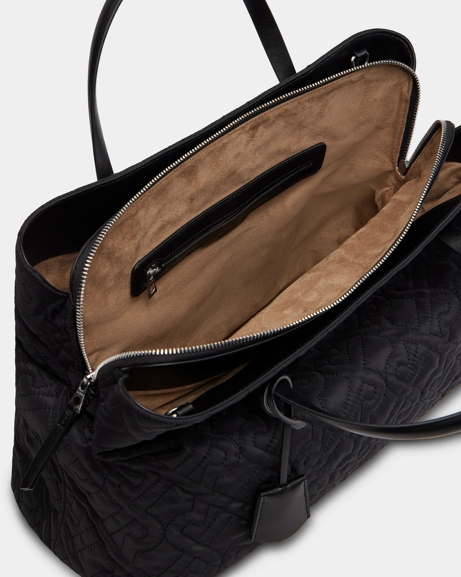 The Rudsak ASMINE - L325005 Black tote features a black quilted exterior, beige suede interior, zippered pocket, main compartment, leather handles, and silver zipper hardware—an elegant work bag for any occasion.