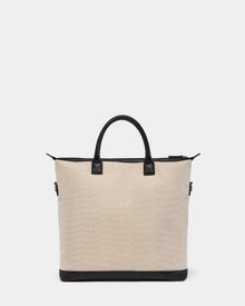 The Rudsak DEXTER - 9324513 Vanilla is a beige canvas tote with black leather handles, trim, and base. Its zippered top and rectangular shape make this unisex bag a versatile accessory for any occasion. Displayed on a plain white background.