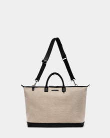 The Rudsak DUBLIN - 9324514 Vanilla is a unisex canvas leather tote with black handles, an adjustable shoulder strap, and sturdy black base—ideal as a weekender bag, shown against a plain white background.
