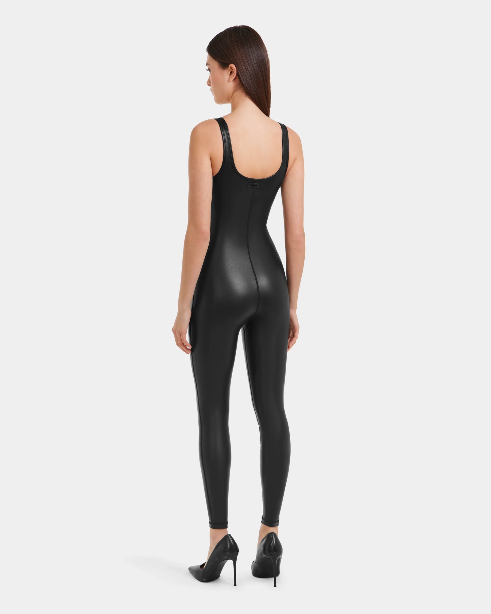A woman wears the LAWREN - 8523047 Black vegan leather bodysuit by Rudsak.