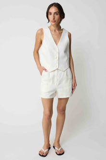 Woman wearing a white tencel vest and white linen shorts