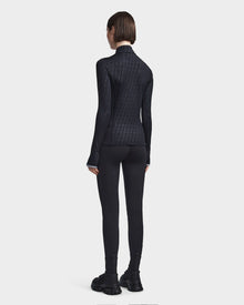 A person with short brown hair faces away, wearing the Rudsak SIRE - 8523531 Black Pattern fleece-lined jersey top and matching leggings—ideal for cold weather style—against a plain white background.
