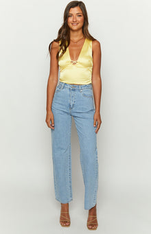 Criss-cross strap detail at the deep V-neckline of the yellow satin top