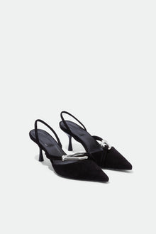 Black suede slingback heels with pointed toes and metal knot detail on the vamp.