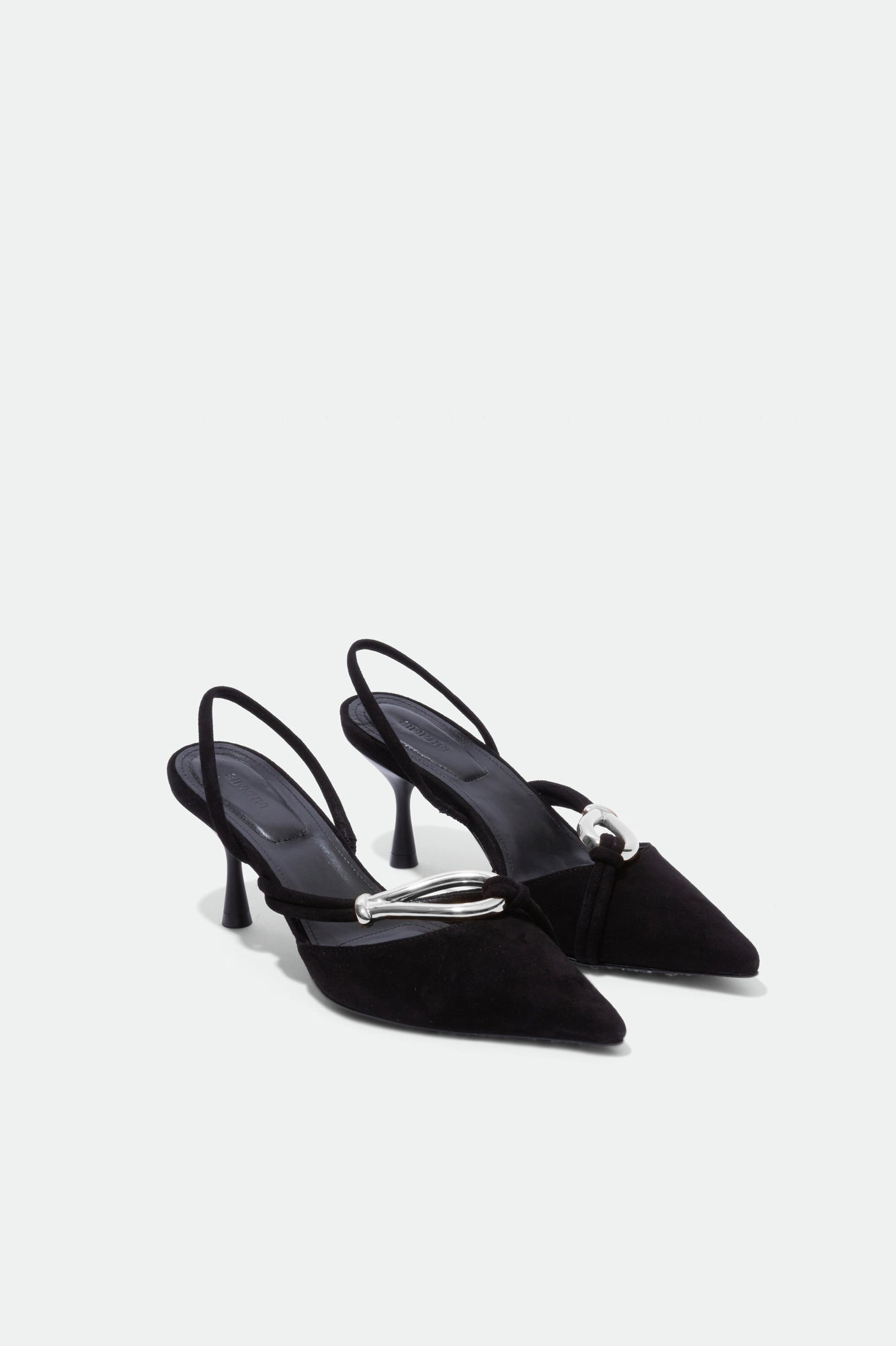 Black suede slingback heels with pointed toes and metal knot detail on the vamp.