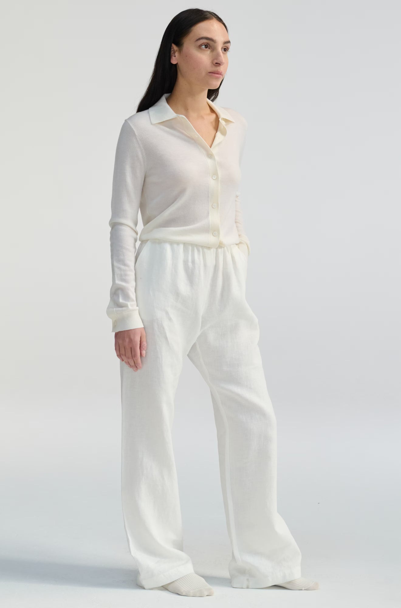 Woman wearing a white outfit on a plain background