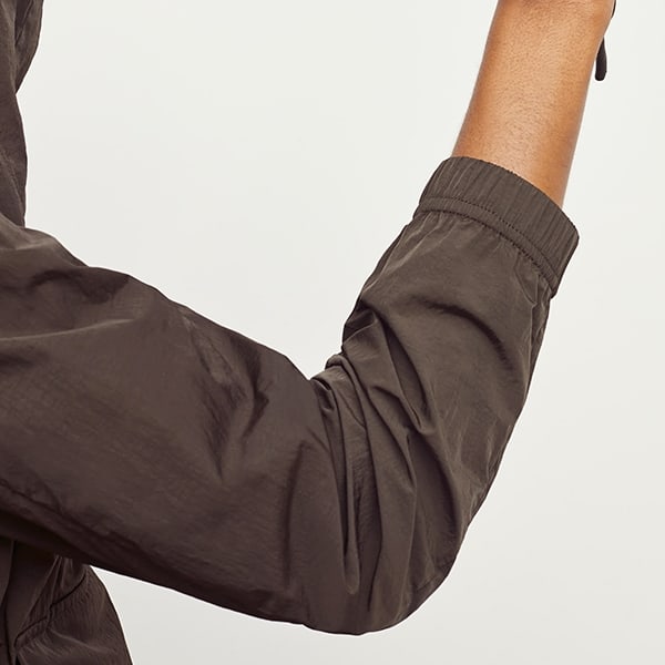 Detail image of a woman standing wearing the Britt Hoodie—AirTech in Dark Moss | Exclude